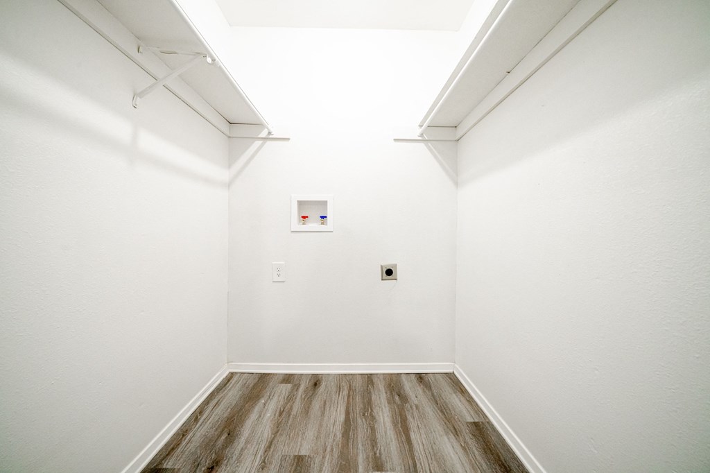 an empty room with white walls and wood floors