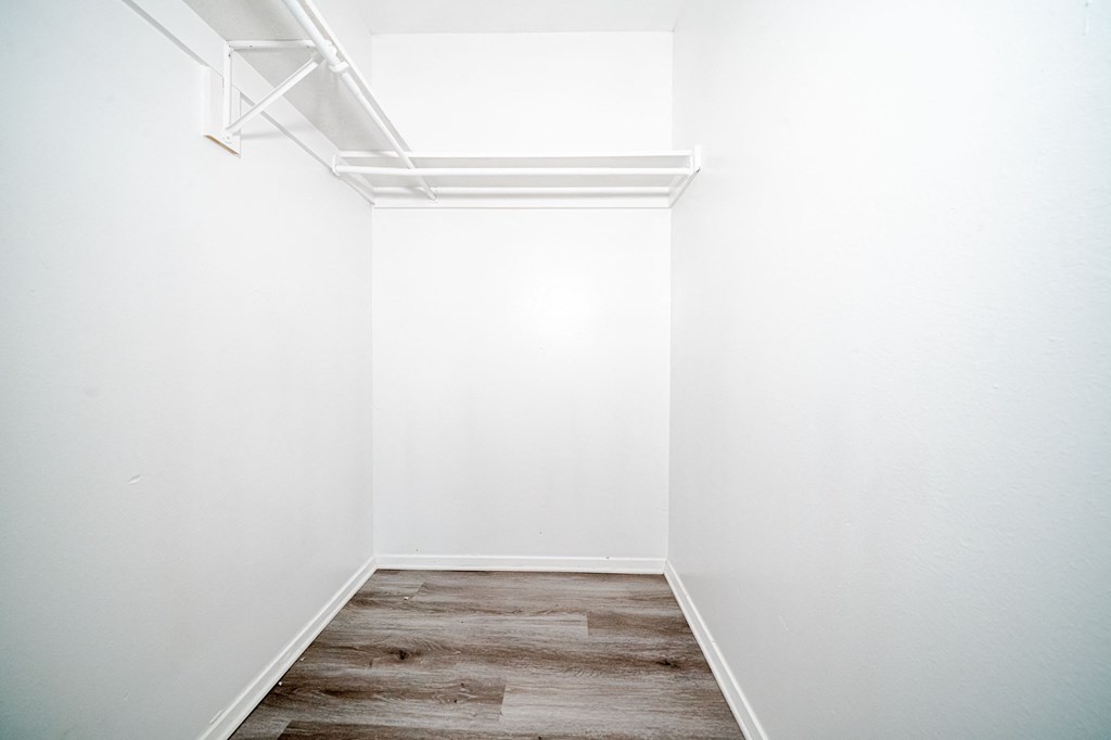 an empty room with white walls and wood floors
