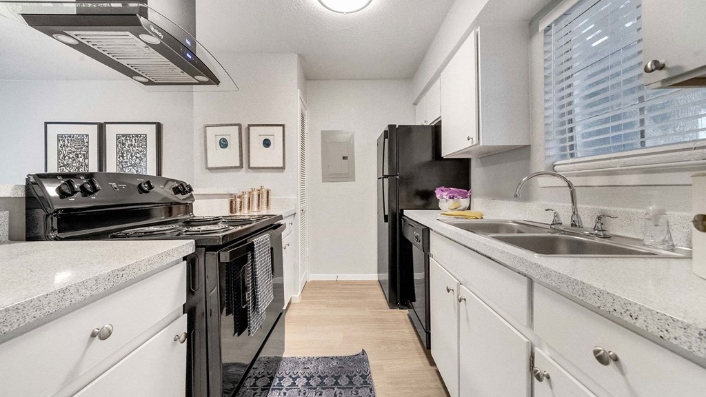 a kitchen with white cabinets and black appliances