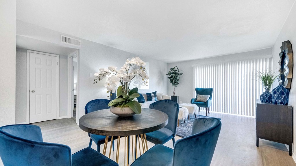a living room with blue chairs and a table with flowers