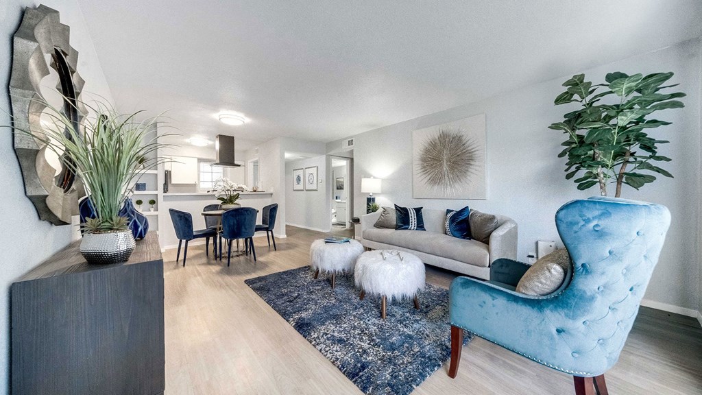 a living room with a couch and chairs and a dining table