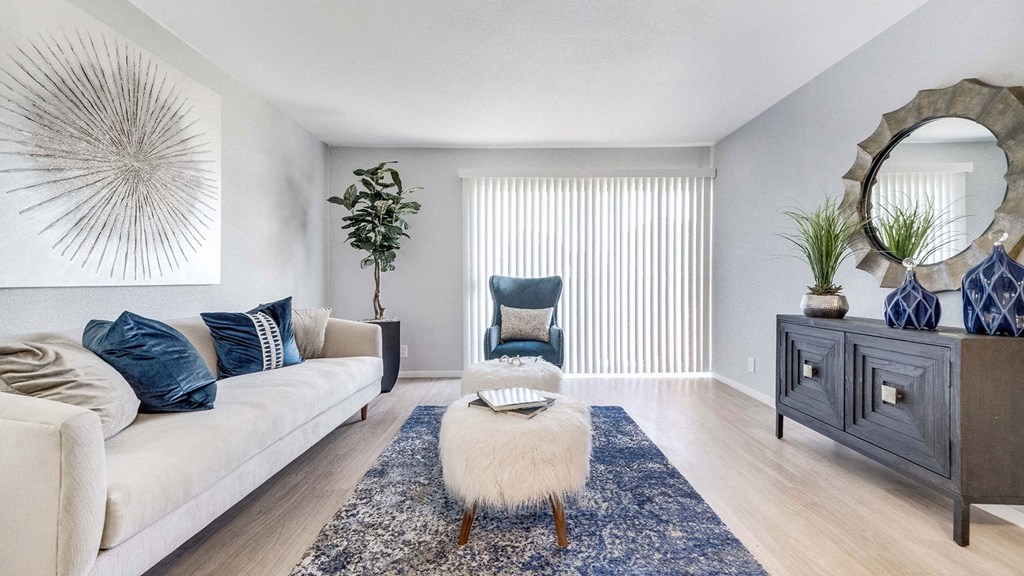 a living room with a white couch and a chair and a blue rug