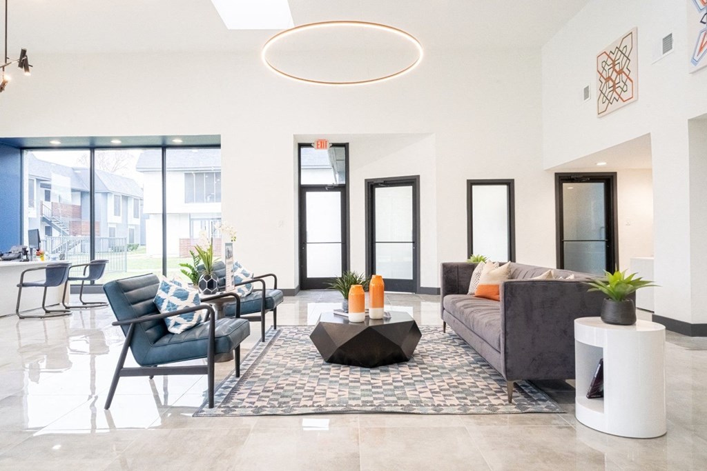 a living room with a couch and chairs and a coffee table