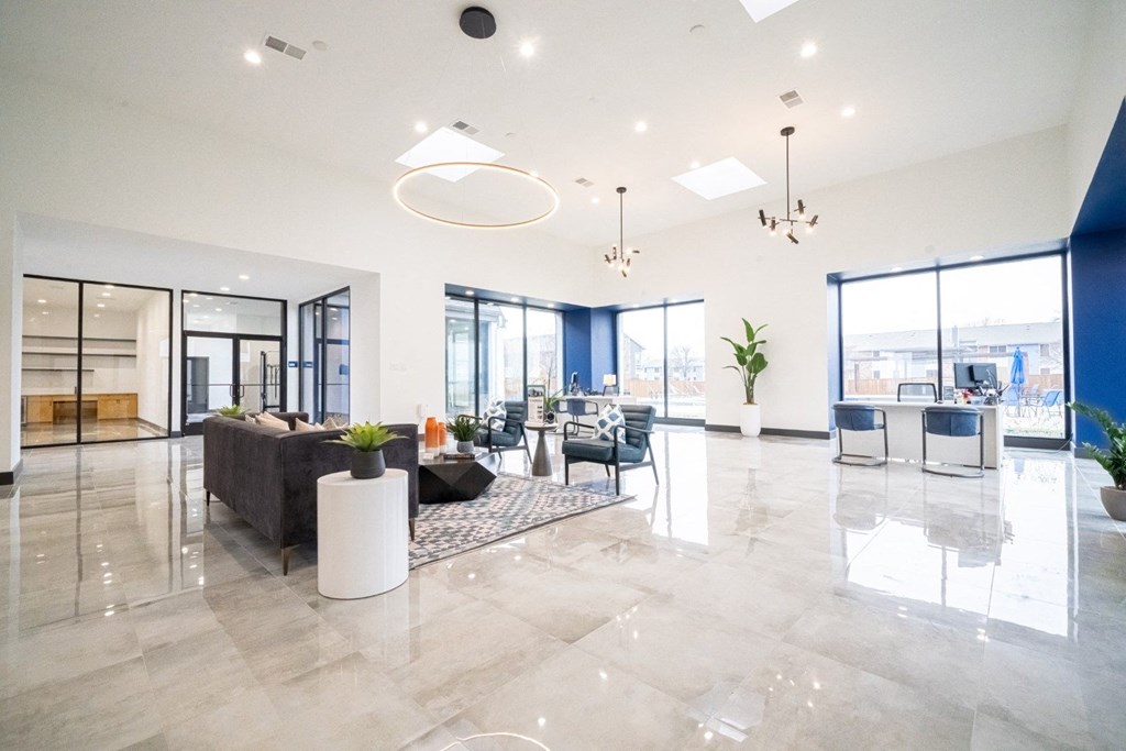 a large living room with a couch and chairs in front of glass doors
