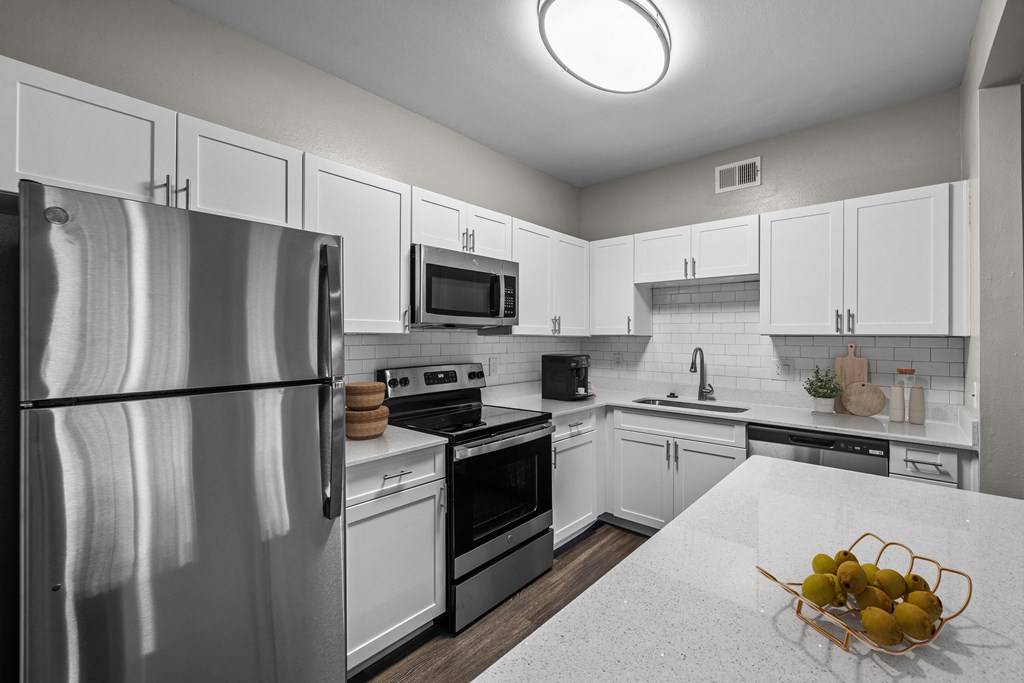 a kitchen with white cabinets and stainless steel appliances