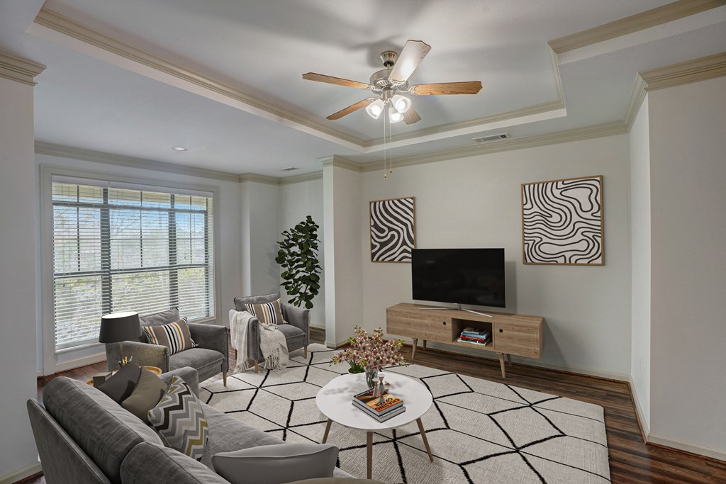 a living room with a ceiling fan and a television
