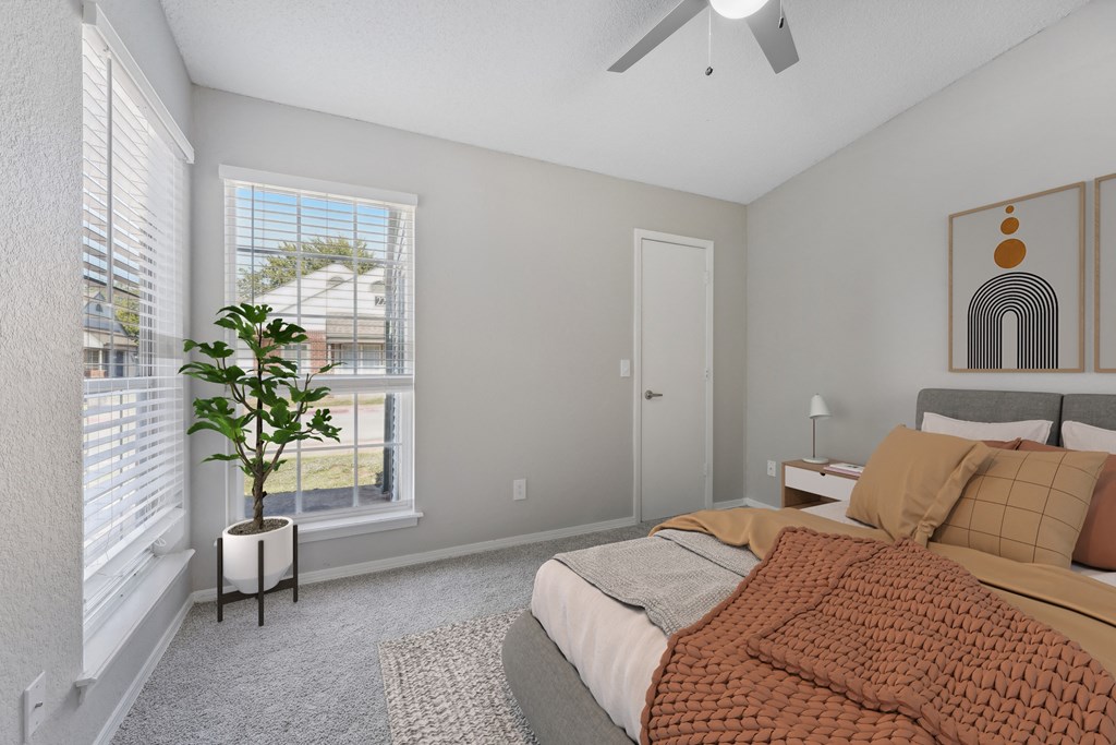 a bedroom with a bed and two windows and a ceiling fan