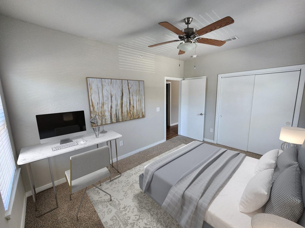 a bedroom with a bed and a desk with a computer