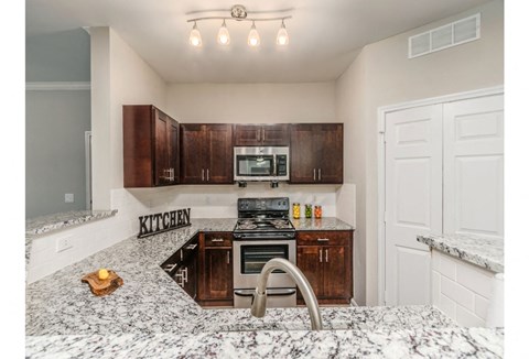 a kitchen with granite counter tops and wooden cabinets