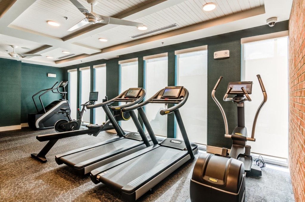 a gym with treadmills and other exercise equipment in a room