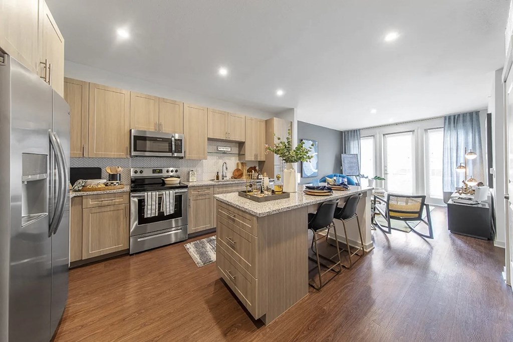 a kitchen with a center island and a stainless steel refrigerator