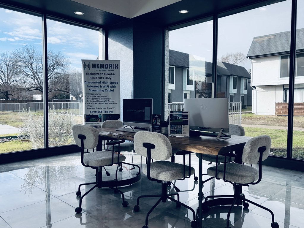 A sign in a room with a table and chairs advertises a sale.