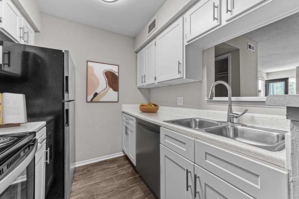 a kitchen with stainless steel appliances and white cabinets