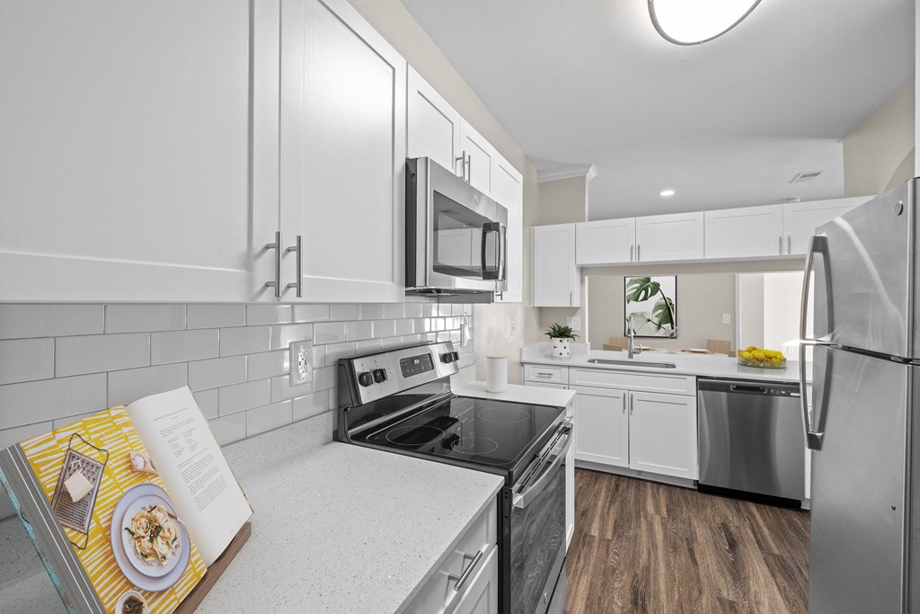 a kitchen with white cabinets and stainless steel appliances