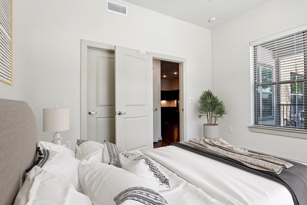 a bedroom with a large bed and a door to a bathroom