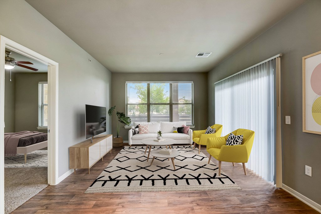 an open living room with a white couch and yellow chairs