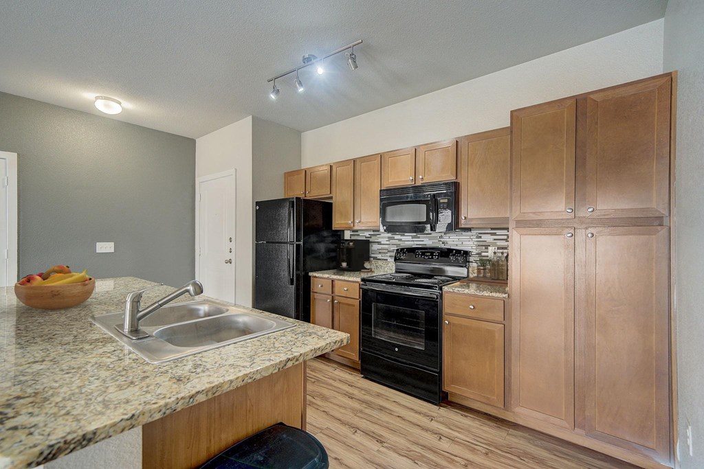 a kitchen with wooden cabinets and black appliances