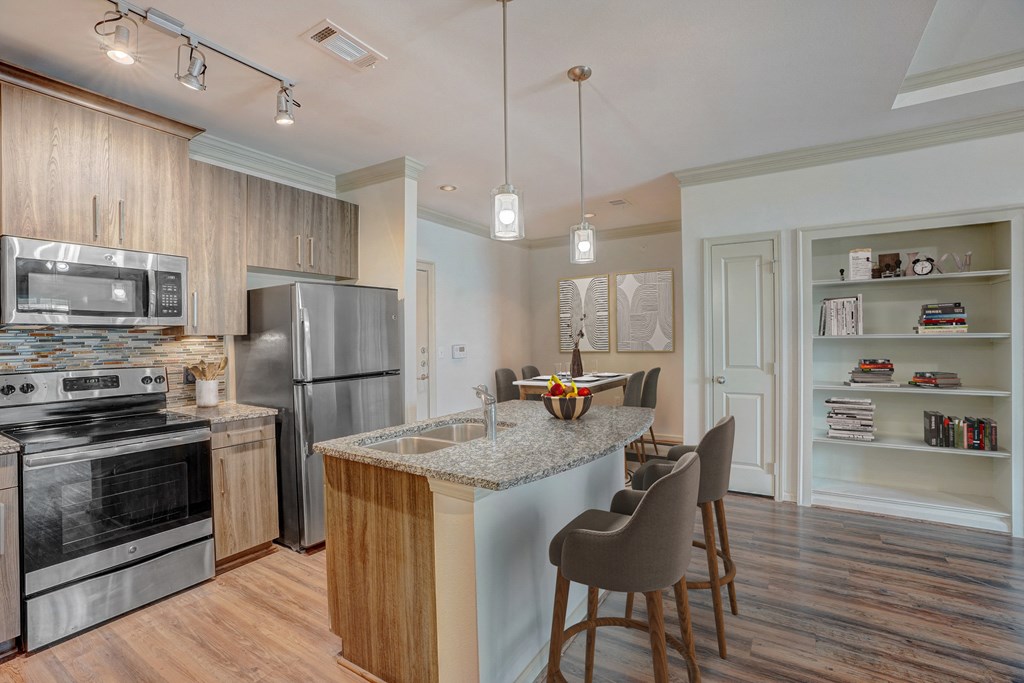 a kitchen with stainless steel appliances and a island with chairs
