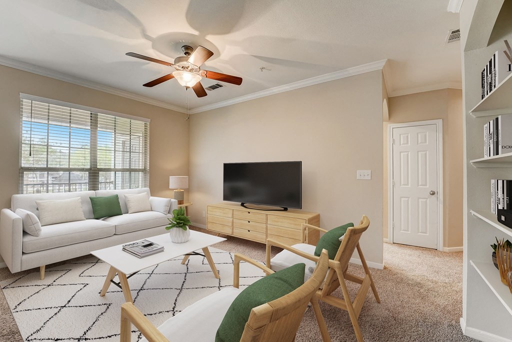 a living room with a ceiling fan and a television