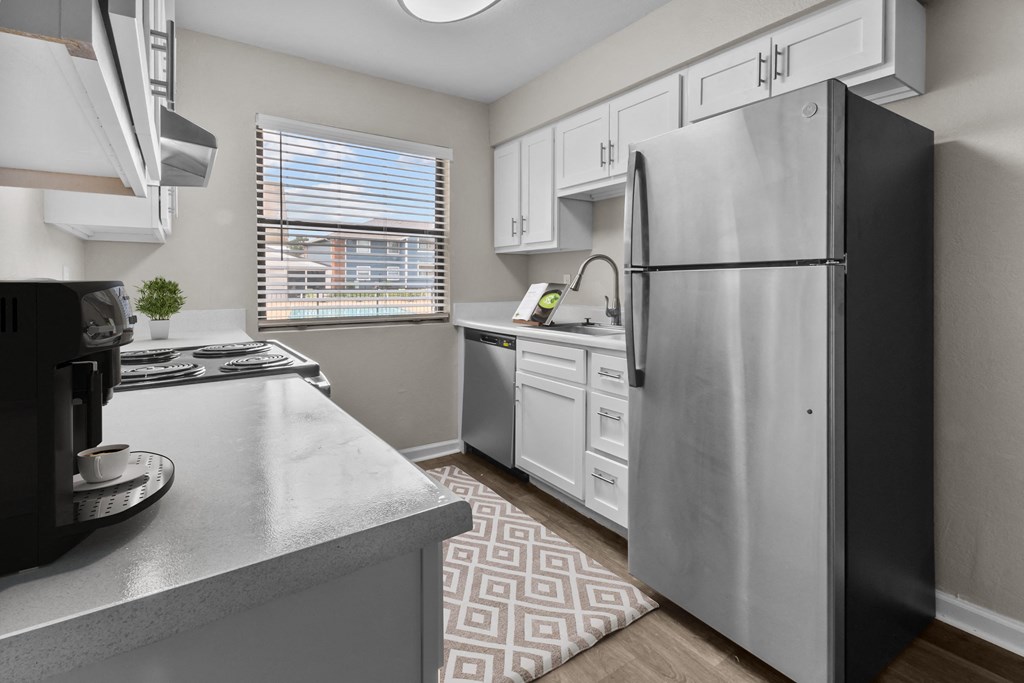 an open kitchen with stainless steel appliances and white cabinets