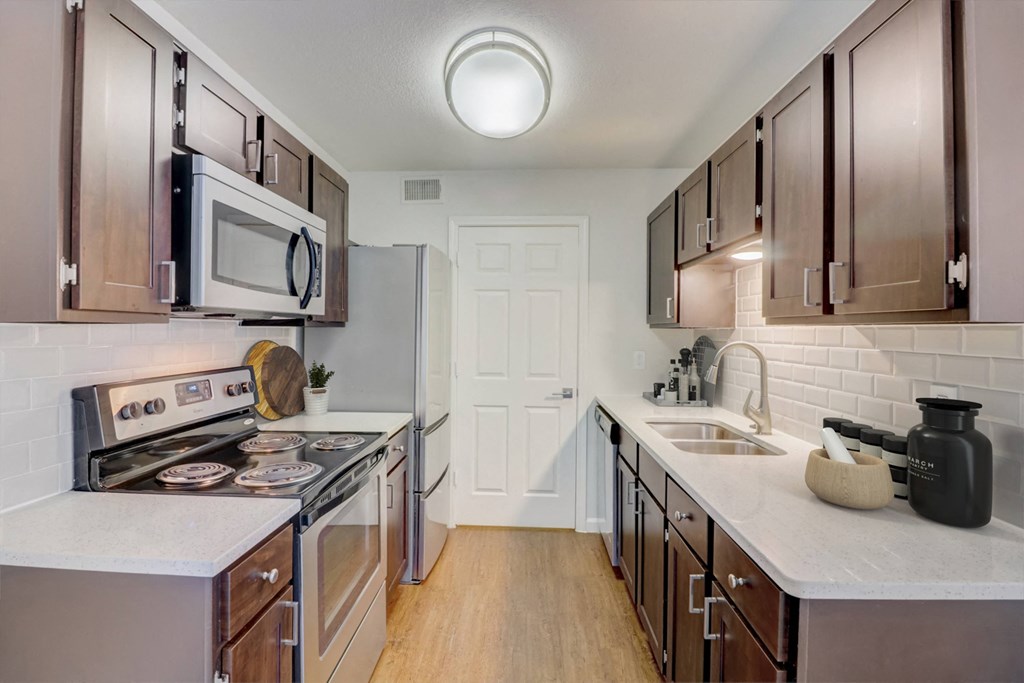 a kitchen with stainless steel appliances and white counter tops