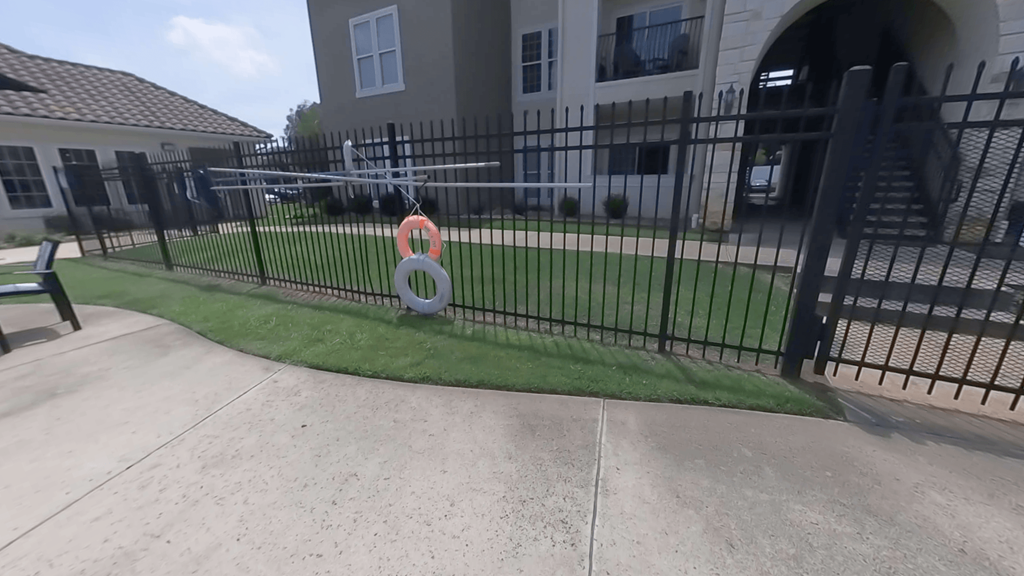 A black fence with a red and white sign in front of a building.