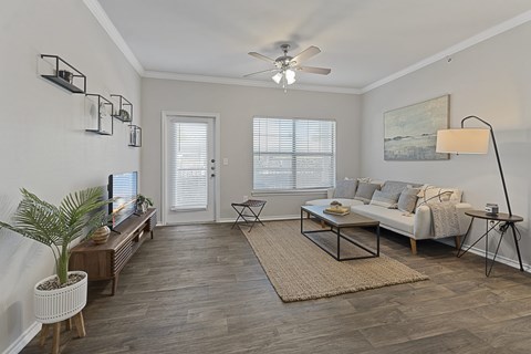 A living room with a white couch, a coffee table, and a ceiling fan.