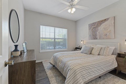 A bedroom with a large bed and a ceiling fan.