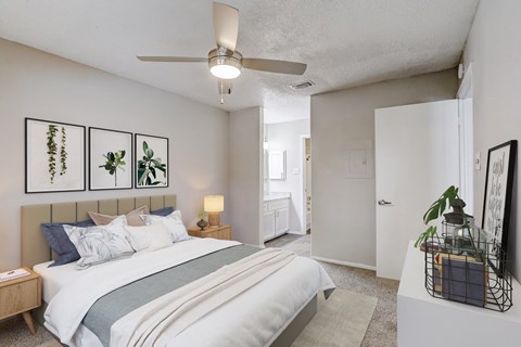 our apartments offer a bedroom with a large bed and a ceiling fan