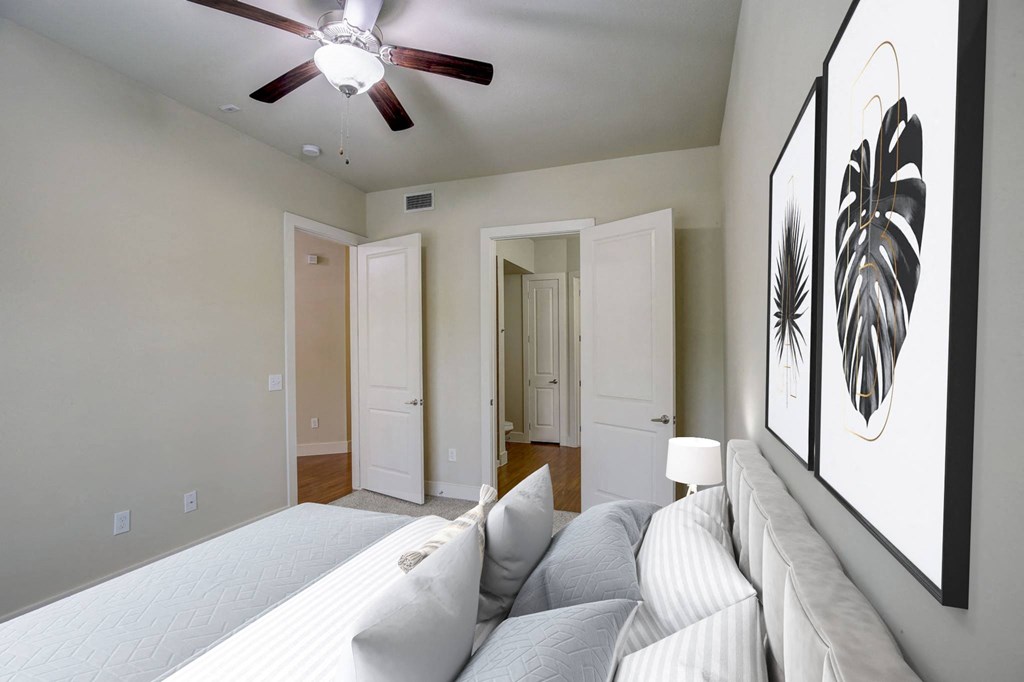 a bedroom with a large bed and a ceiling fan