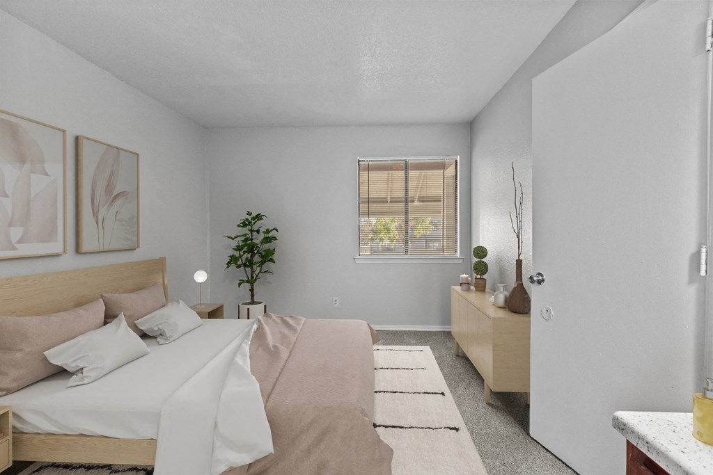 a bedroom with a bed and a dresser and a window