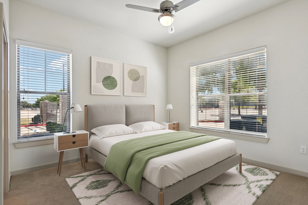 a bedroom with a bed and two windows