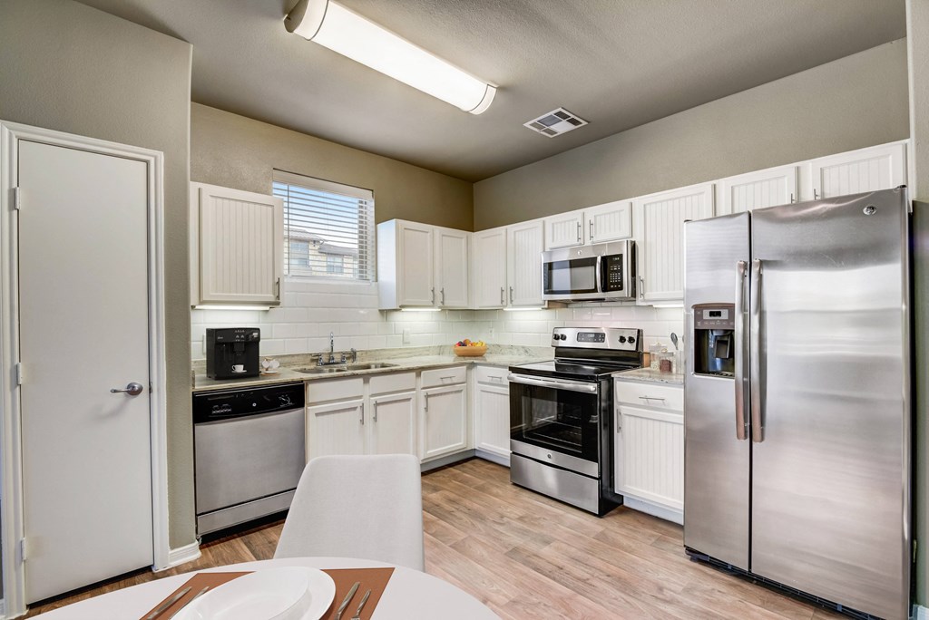 a kitchen with stainless steel appliances and white cabinets