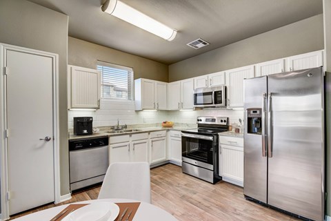 a kitchen with stainless steel appliances and white cabinets