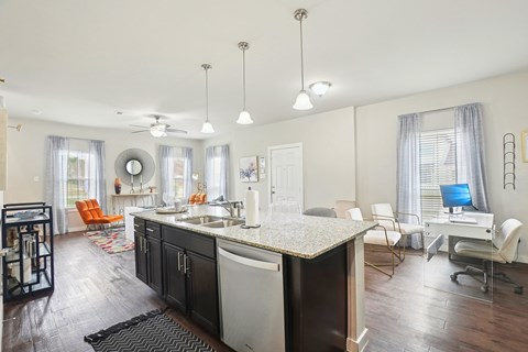 A kitchen with a black and white counter top and a ceiling fan.