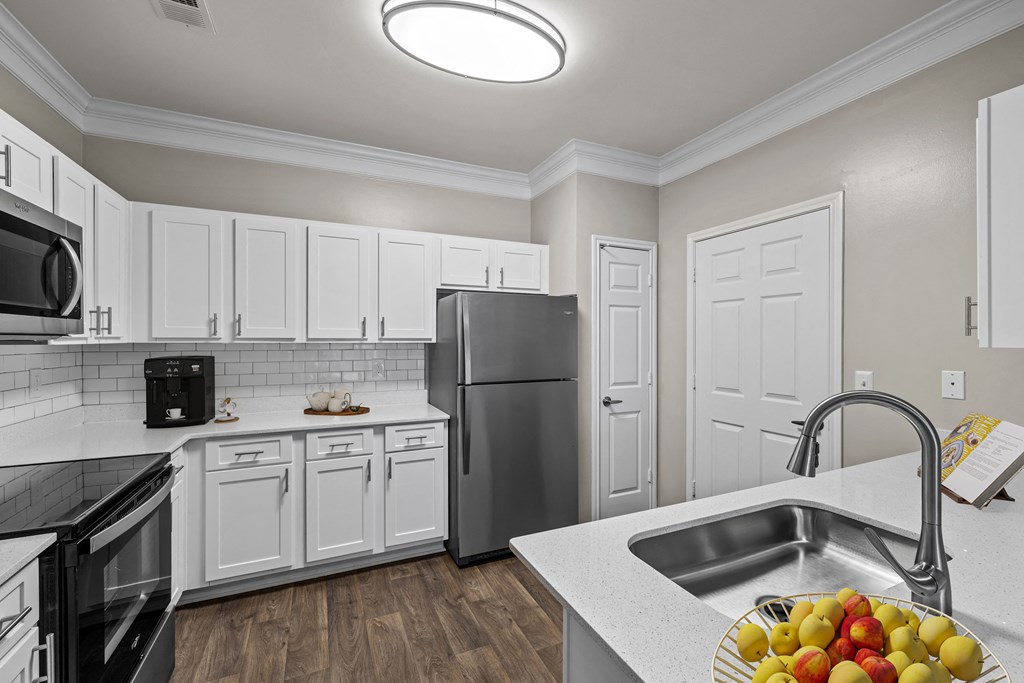a kitchen with white cabinets and stainless steel appliances