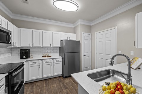a kitchen with white cabinets and stainless steel appliances