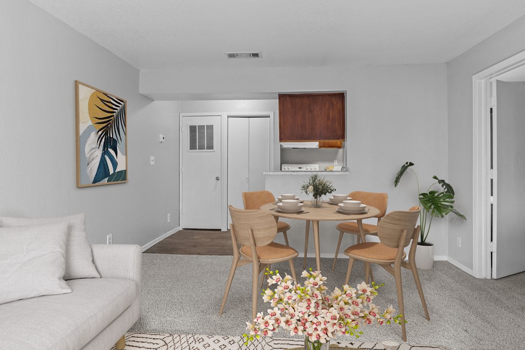 a living room and dining room with a table and chairs