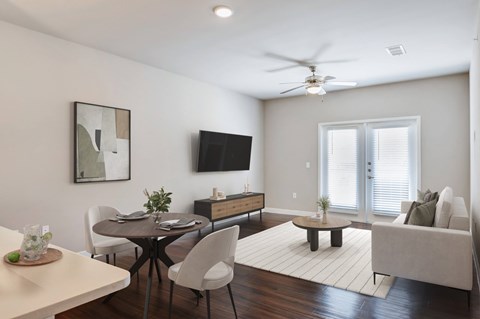 A modern living room with a dining table and chairs.