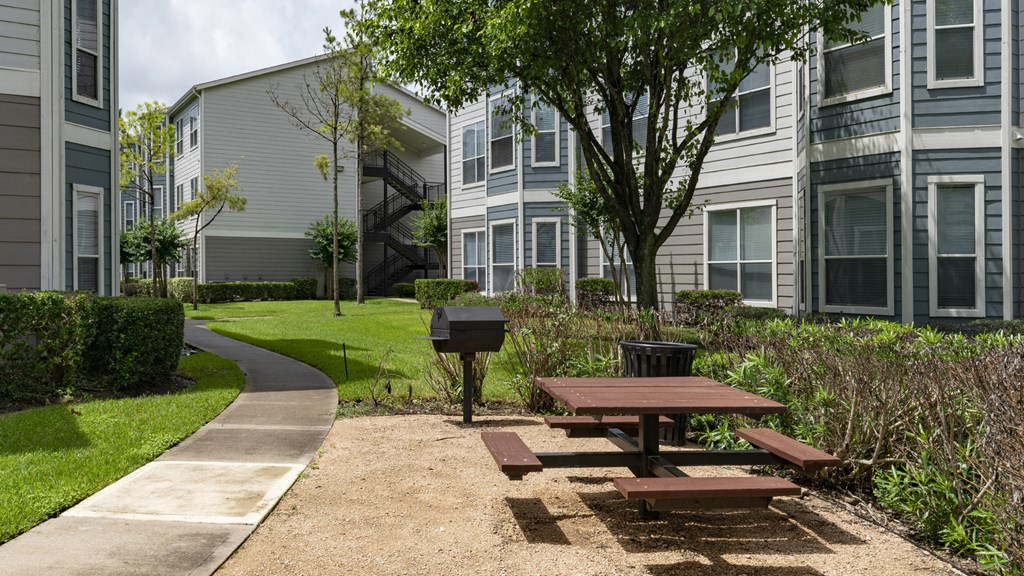 a picnic area with a picnic table in front of an apartment building