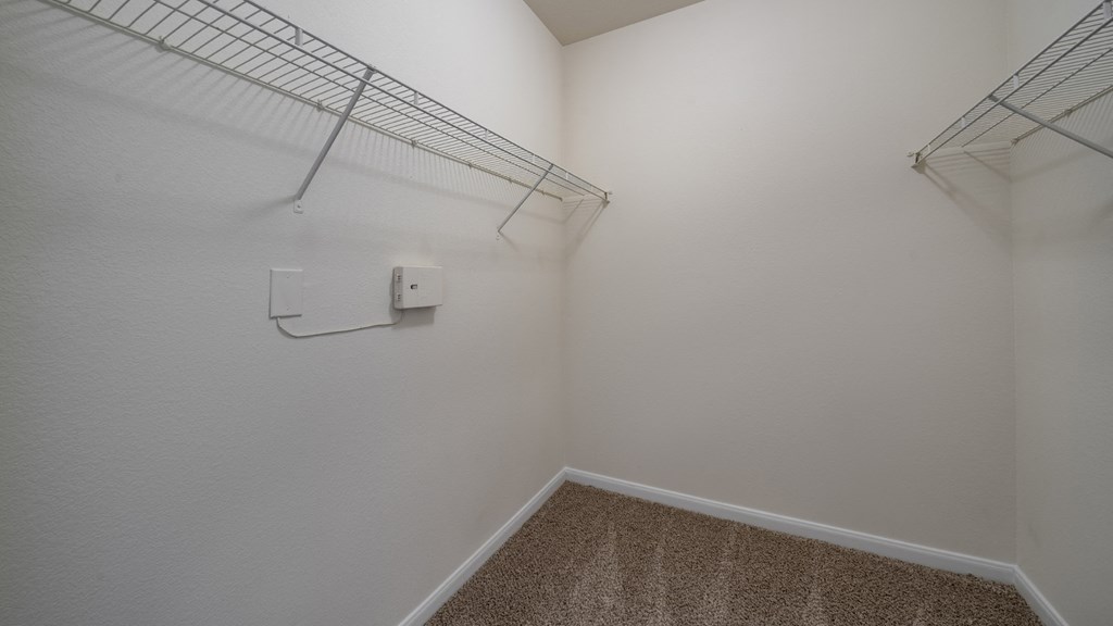 a room with a closet and a wire rack on the wall