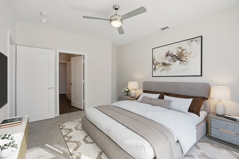 A bedroom with a large bed and a ceiling fan.