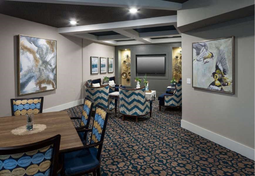 a dining room with tables and chairs and paintings