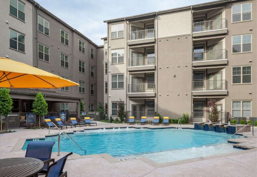 a swimming pool in front of an apartment building