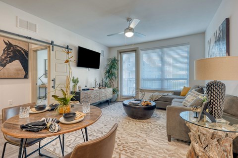 A living room with a wooden table and chairs.