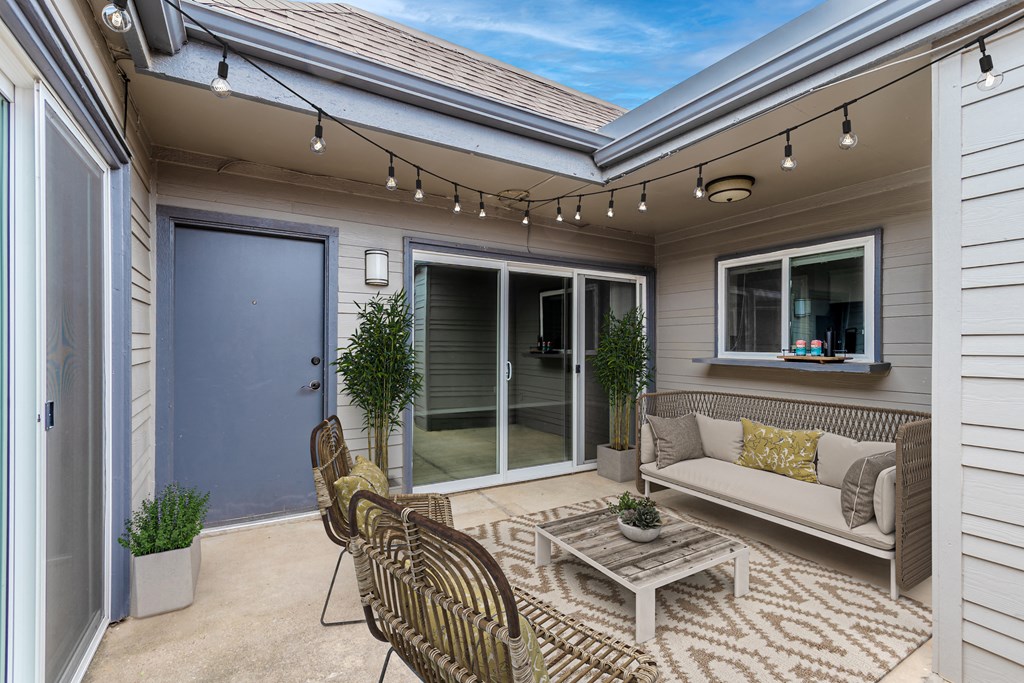 a patio with a couch and chairs and a coffee table