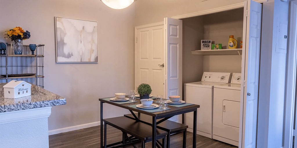 an open kitchen and dining area with a table and chairs and a refrigerator