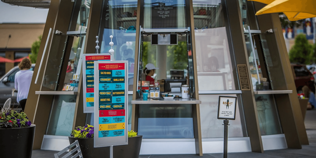 a door to a restaurant with a sign in front of it