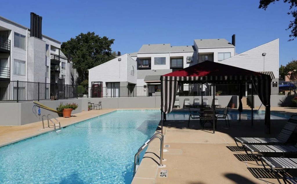 our apartments have a swimming pool with a gazebo and chairs