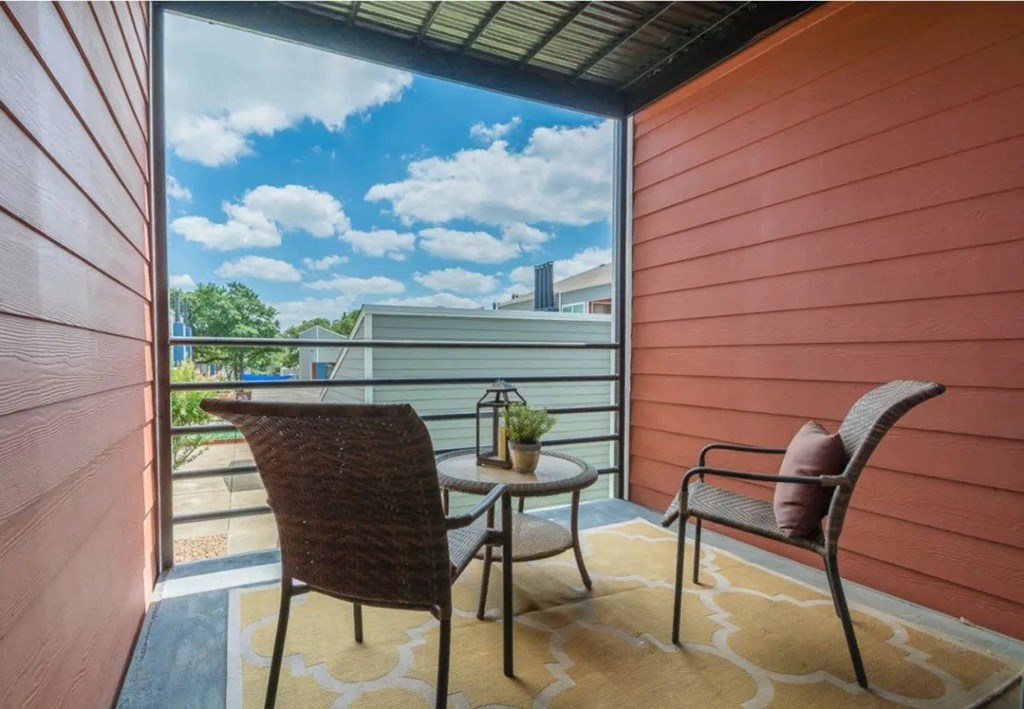 a balcony with two chairs and a table